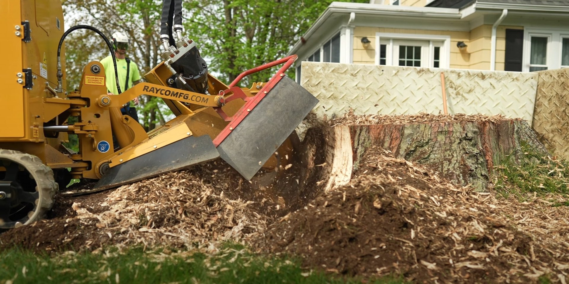 Residential Stump Removal - Complete stump grinding service for homeowner properties Professional stump grinder processing large tree stump in residential backyard near wooden fence